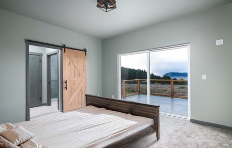 Aspen Custom Home Bedroom Modern bedroom with sliding barn door balcony