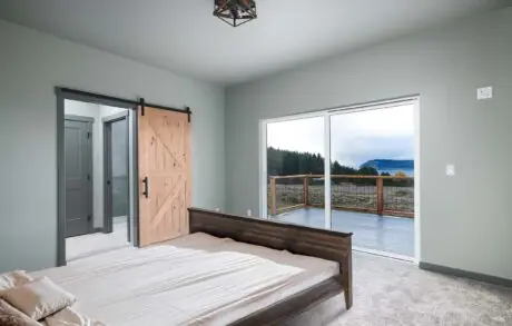 Aspen Custom Home Bedroom - Inspire Homes Modern bedroom with sliding barn door balcony