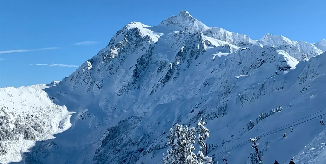 Snowy mountain landscape with clear blue sky.