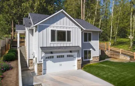 Custom Home Walden_Loop – Front - Inspire Homes Modern suburban house with lush green surroundings