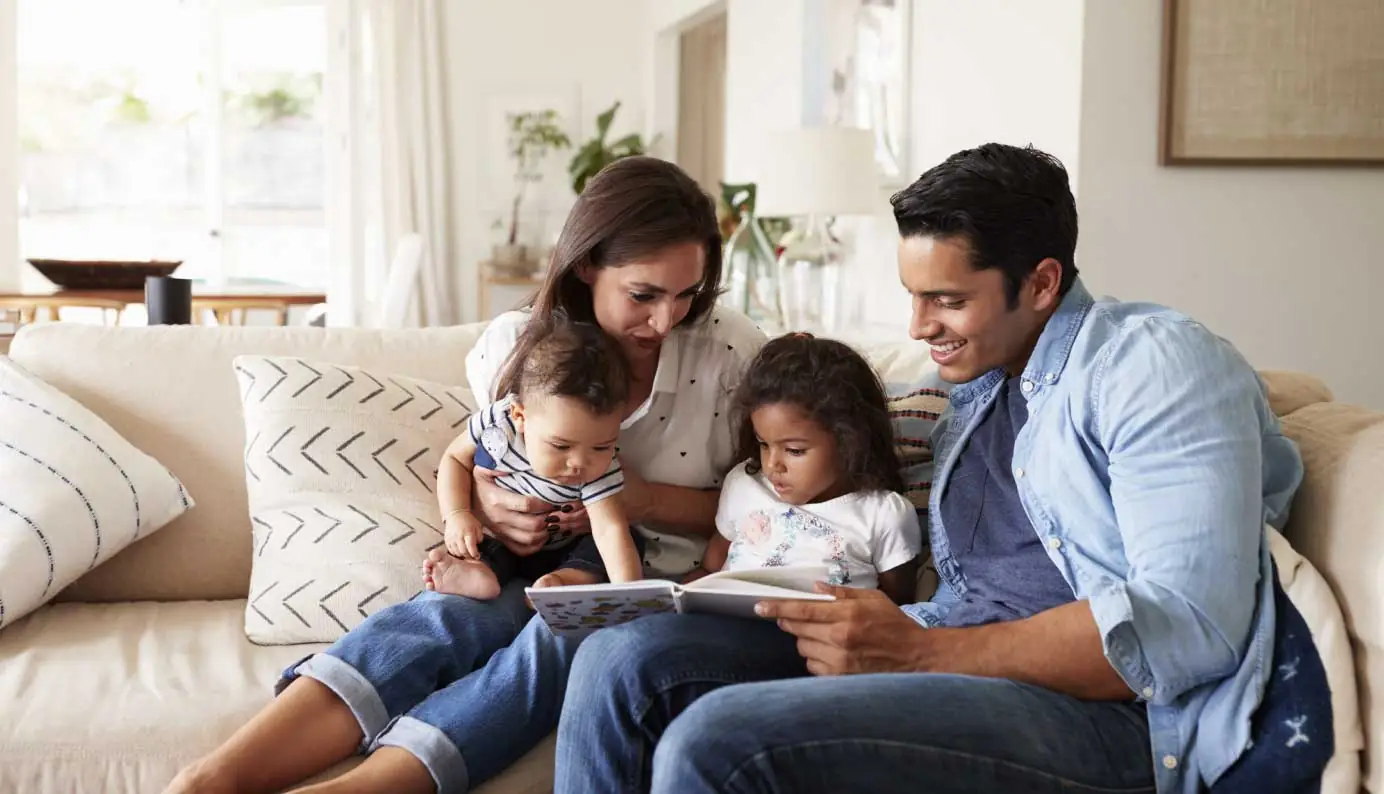 Family reading together on cozy living room sofa