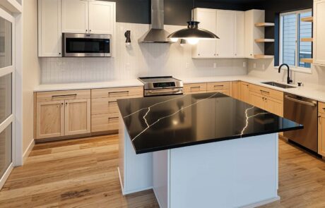 Inspire Homes Juniper Welch Kitchen Modern kitchen with black marble island countertop.