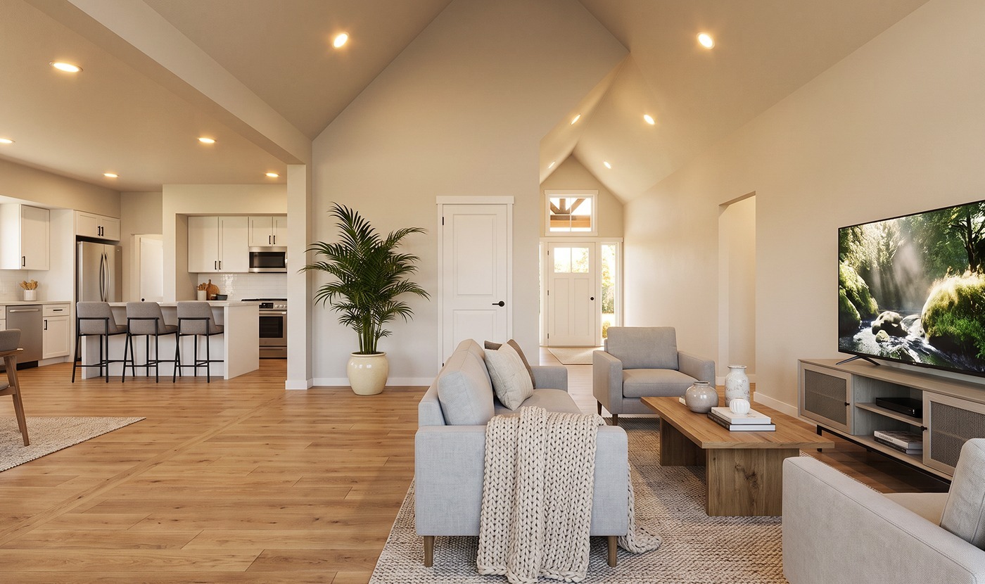 Open-concept living room with a gray sofa, wooden coffee table, large TV, and a vaulted ceiling; kitchen with an island and bar stools in the background.