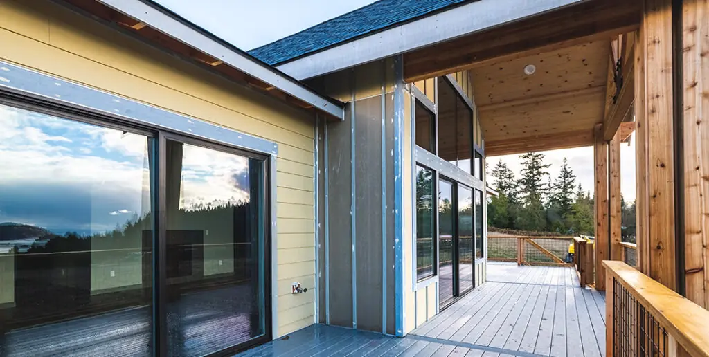 Quality Materials2 - Inspire Homes Modern house exterior with spacious wooden deck.