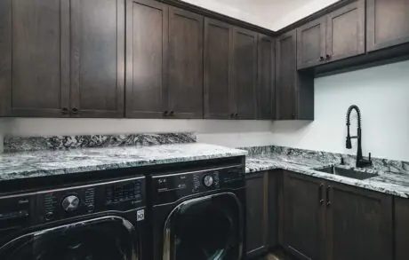 Redwood Custom Laundry - Inspire Homes Modern laundry room with dark wood cabinets