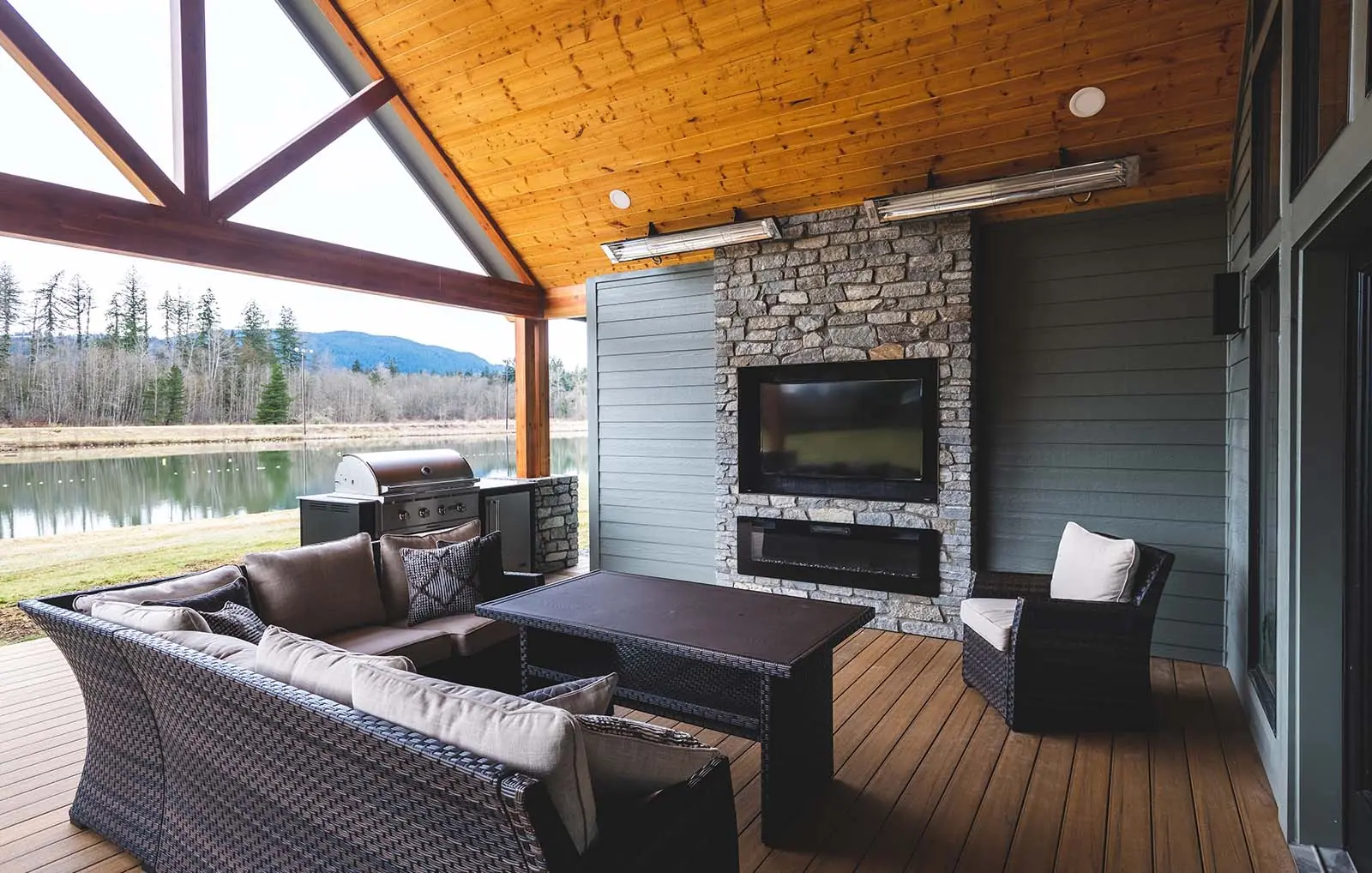Covered outdoor patio with modern seating and fireplace.